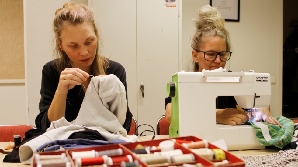 Lina Östling och Therese Pettersson arbetar med sina projekt; att laga ett hål med en synlig söm och att göra om en klänning till en kjol.